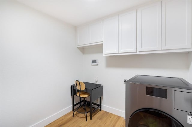 laundry area featuring washer / dryer, cabinet space, light wood-type flooring, and baseboards