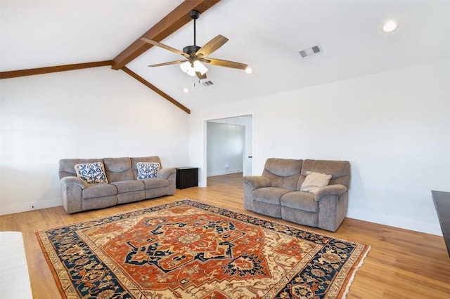 living area featuring visible vents, vaulted ceiling with beams, and light wood-type flooring