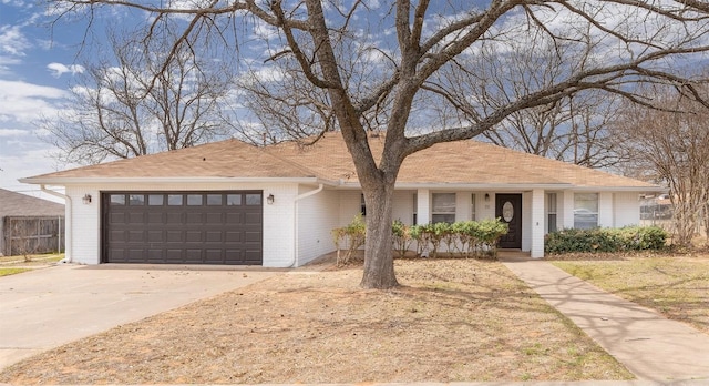 ranch-style home with brick siding, concrete driveway, an attached garage, and fence