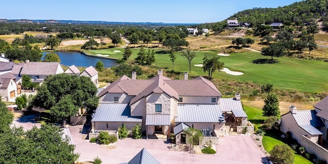 drone / aerial view featuring view of golf course and a water view