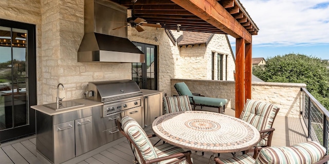 wooden deck featuring exterior kitchen, outdoor dining area, a sink, ceiling fan, and a grill