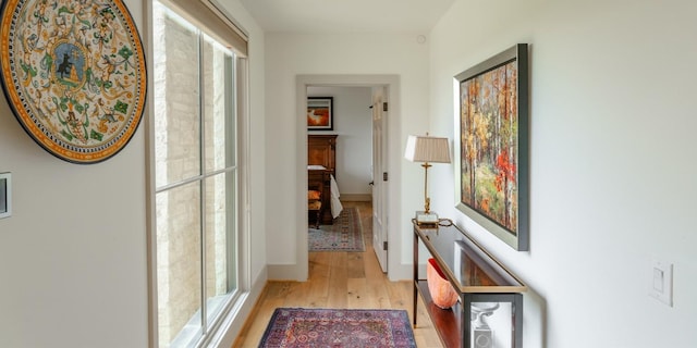 hall featuring baseboards and light wood finished floors