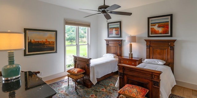 bedroom with ceiling fan, baseboards, and wood finished floors