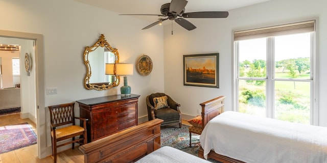 bedroom featuring wood finished floors, baseboards, and ceiling fan