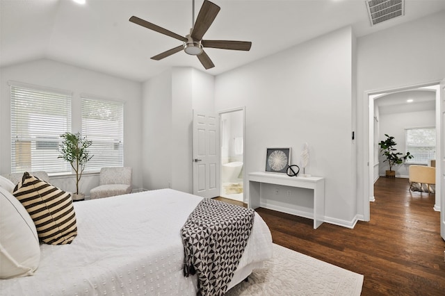 bedroom featuring visible vents, wood finished floors, connected bathroom, baseboards, and vaulted ceiling