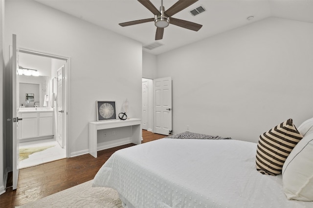 bedroom with visible vents, ensuite bath, wood finished floors, baseboards, and vaulted ceiling