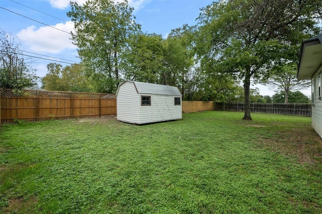 view of yard with an outbuilding, a storage unit, and a fenced backyard