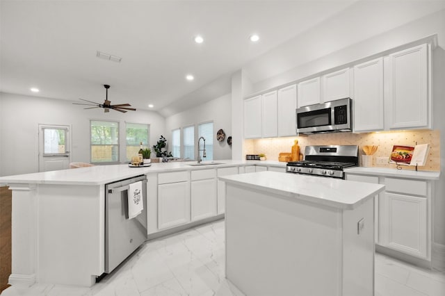 kitchen featuring visible vents, a sink, appliances with stainless steel finishes, marble finish floor, and a center island