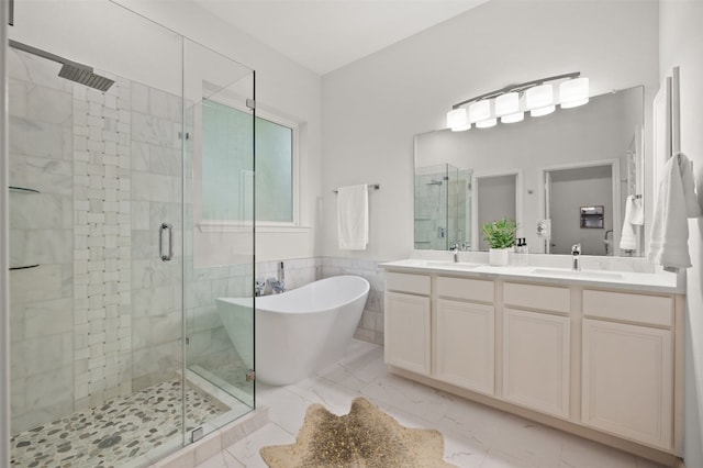 bathroom featuring a sink, marble finish floor, and a stall shower