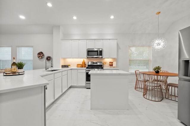 kitchen featuring marble finish floor, a sink, backsplash, recessed lighting, and appliances with stainless steel finishes