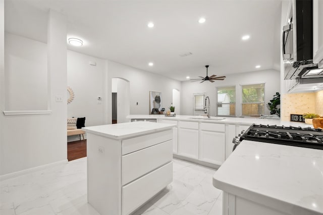 kitchen featuring recessed lighting, arched walkways, ceiling fan, a sink, and marble finish floor