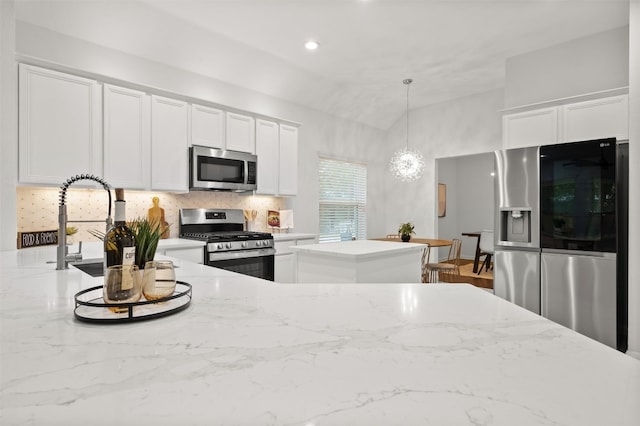 kitchen with light stone counters, stainless steel appliances, decorative backsplash, and white cabinetry