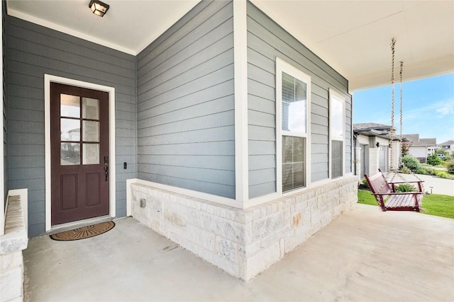 property entrance featuring a porch and stone siding