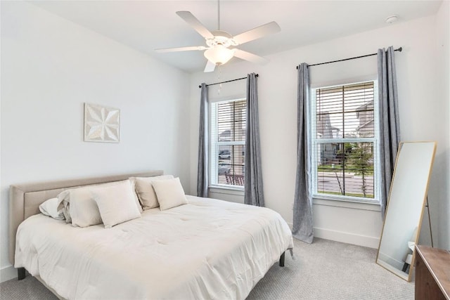 bedroom with baseboards, light colored carpet, and a ceiling fan