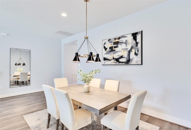 dining room with baseboards, visible vents, and light wood-type flooring