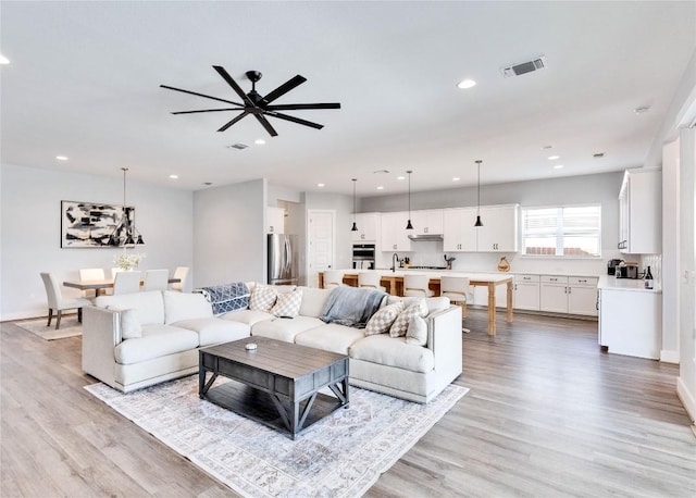 living room featuring visible vents, recessed lighting, light wood-type flooring, and baseboards