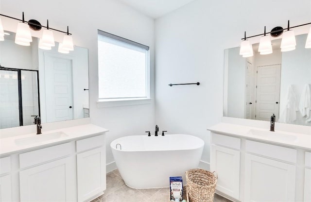 bathroom featuring a freestanding tub, two vanities, a stall shower, and a sink