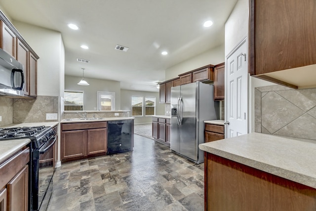 kitchen with tasteful backsplash, visible vents, light countertops, black appliances, and a sink