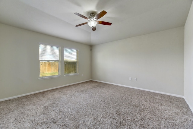 spare room with lofted ceiling, carpet flooring, baseboards, and ceiling fan