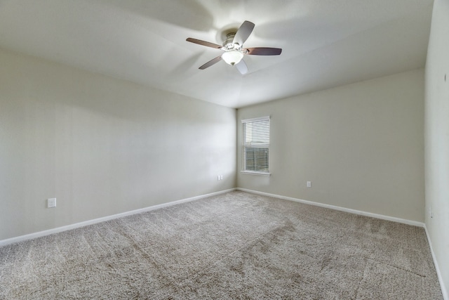 carpeted spare room with baseboards and a ceiling fan