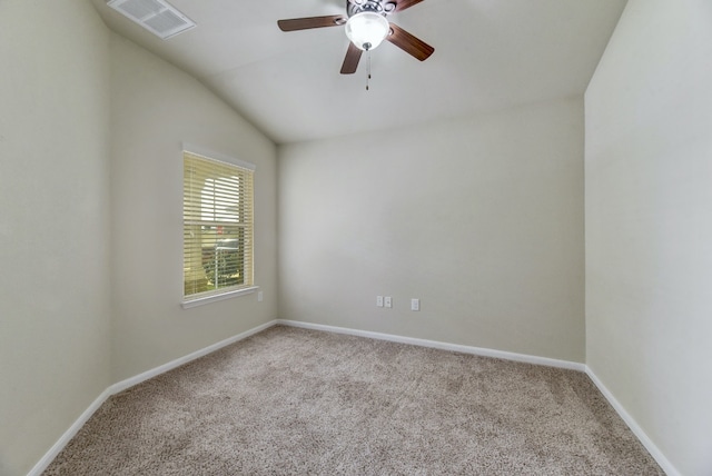 empty room with carpet, baseboards, visible vents, lofted ceiling, and ceiling fan