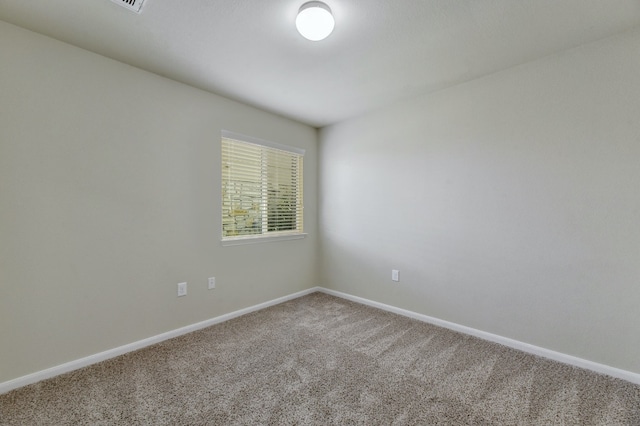 carpeted empty room featuring baseboards