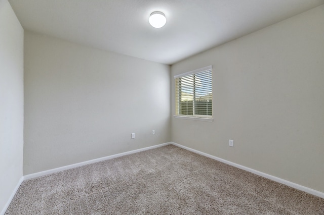 carpeted empty room with baseboards