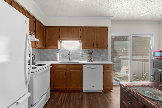 kitchen with white appliances, light countertops, dark wood-type flooring, and a sink