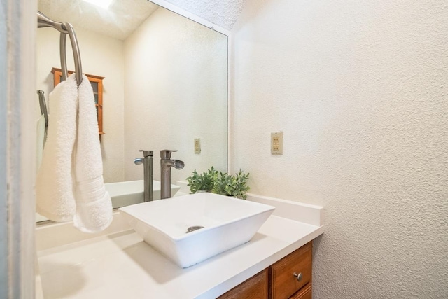 bathroom with vanity and a textured wall