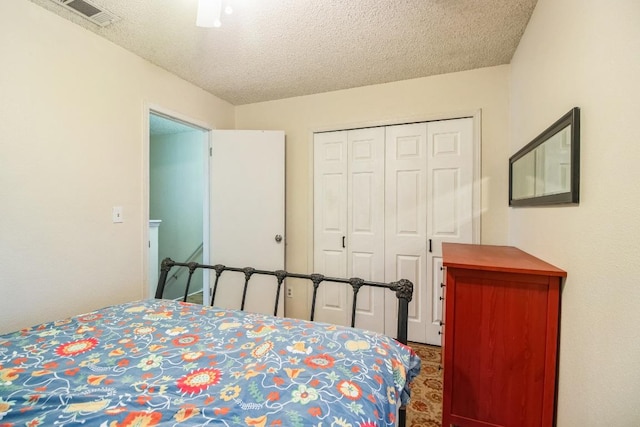 bedroom featuring visible vents, a closet, and a textured ceiling