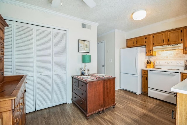 kitchen with white appliances, visible vents, dark wood-type flooring, under cabinet range hood, and crown molding