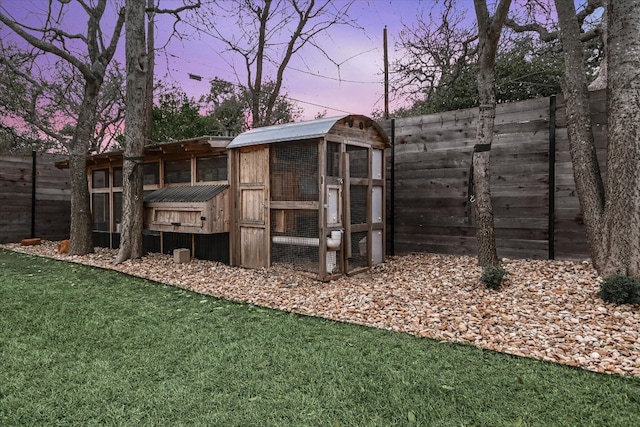 view of play area with an outbuilding, a yard, a fenced backyard, and exterior structure