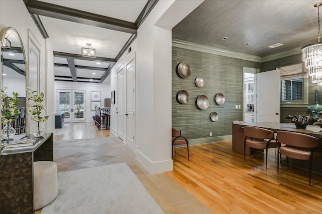 interior space featuring baseboards, a chandelier, ornamental molding, french doors, and light wood-style floors