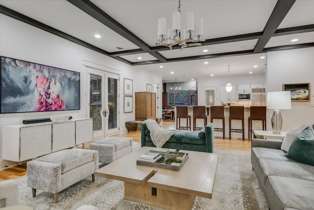 living room with french doors, coffered ceiling, an inviting chandelier, and beamed ceiling