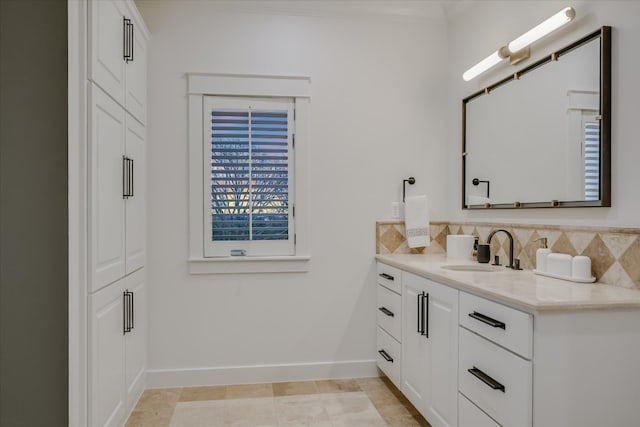 bathroom with baseboards, tasteful backsplash, ornamental molding, and vanity