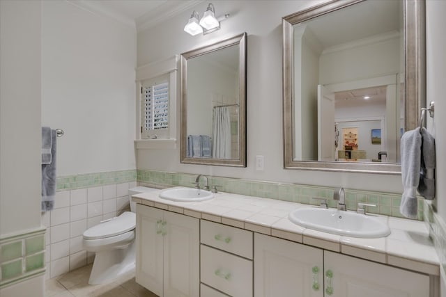 bathroom featuring toilet, double vanity, ornamental molding, and a sink