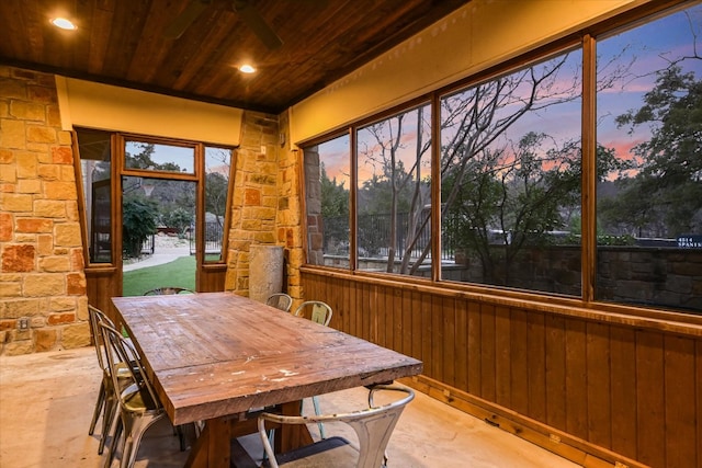 unfurnished sunroom with a ceiling fan, wood ceiling, and a healthy amount of sunlight