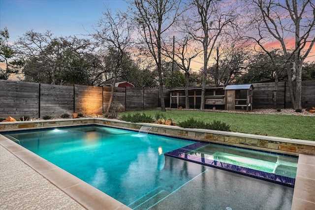 view of swimming pool with a yard, a fenced backyard, and a pool with connected hot tub