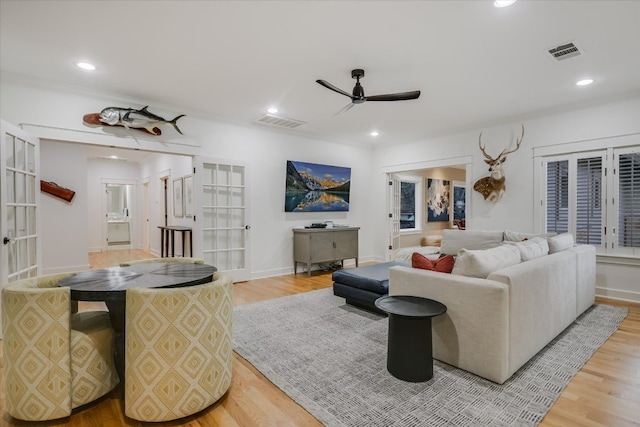 living room featuring light wood-type flooring, visible vents, and recessed lighting