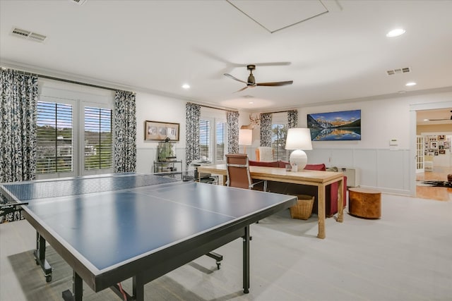 rec room with visible vents, ceiling fan, and wainscoting