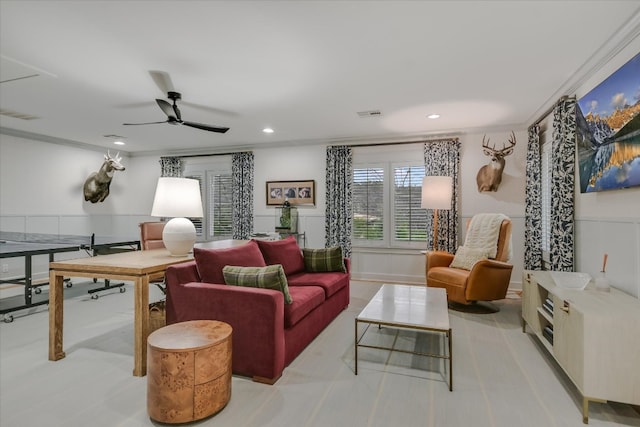 living area with recessed lighting, visible vents, and wainscoting