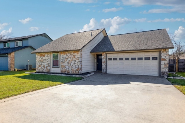 view of front of home featuring a front yard, cooling unit, roof with shingles, an attached garage, and concrete driveway