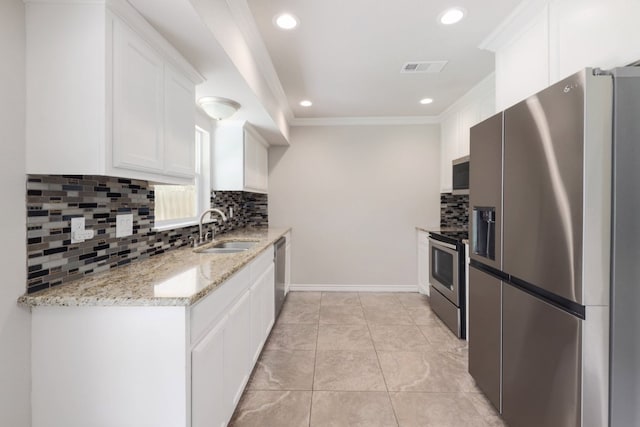 kitchen with light stone counters, ornamental molding, a sink, white cabinets, and appliances with stainless steel finishes