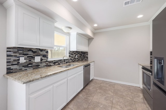 kitchen featuring visible vents, a sink, backsplash, stainless steel appliances, and crown molding