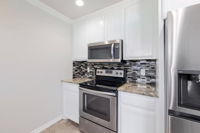 kitchen featuring white cabinets, light stone countertops, tasteful backsplash, and appliances with stainless steel finishes