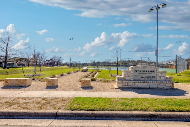 view of community with a lawn and fence