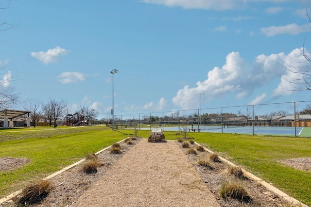 view of yard featuring a tennis court and fence