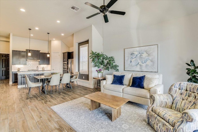 living area featuring light wood-type flooring, visible vents, recessed lighting, and a ceiling fan