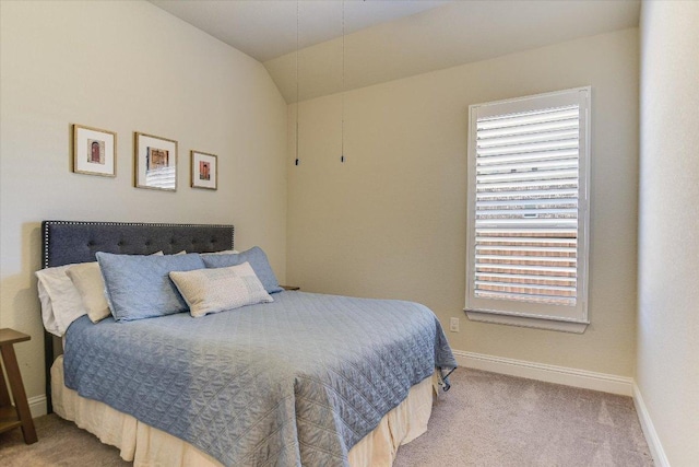 carpeted bedroom with vaulted ceiling and baseboards