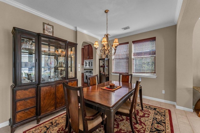 dining space with light tile patterned flooring, baseboards, arched walkways, and ornamental molding